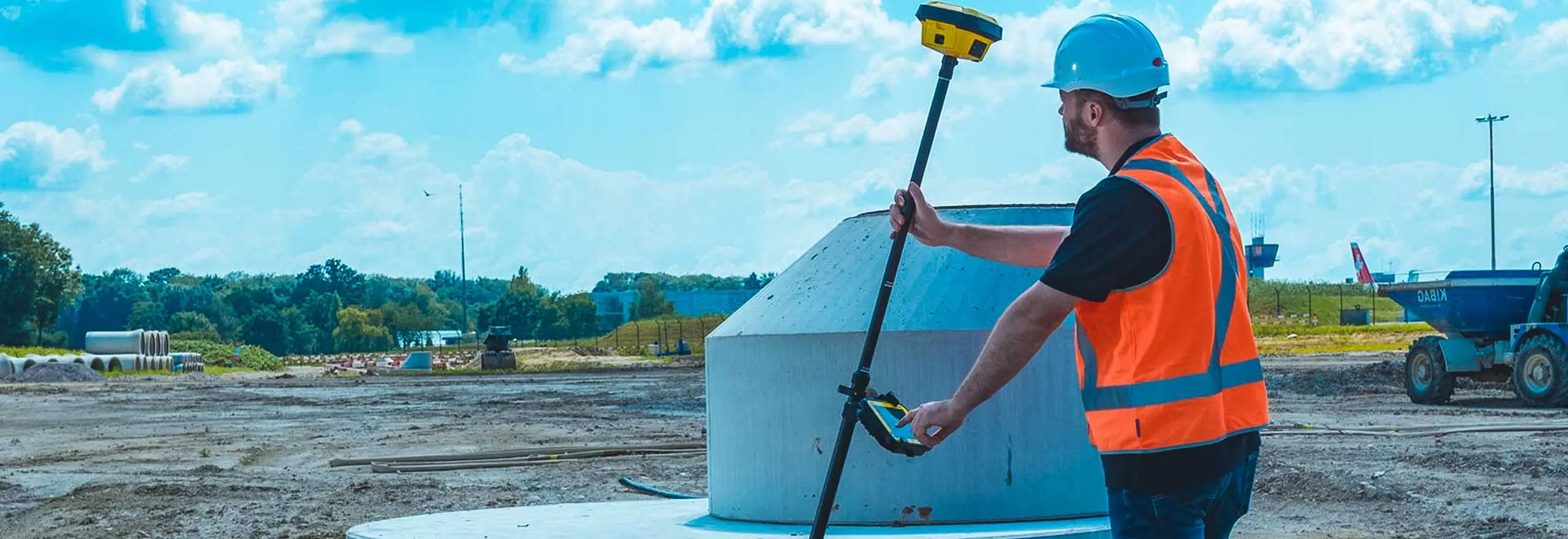 Technicien relevant les coordonnees d'un regard au recepteur GNSS RTK sur un chantier