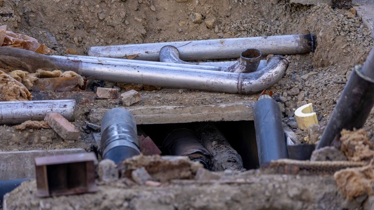 Canalisations et cables enterres mis a nu dans une tranchee de chantier